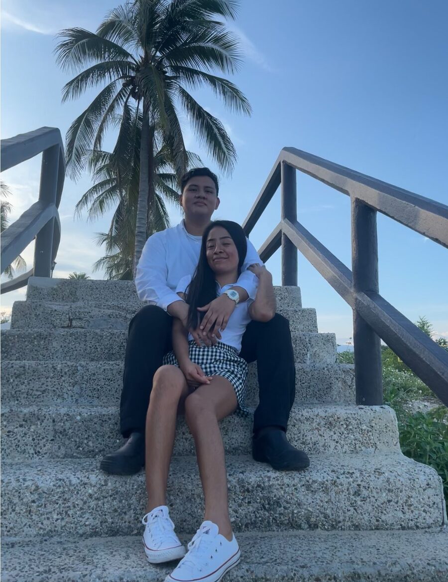 Jordi y Ana Yeli sentados en escaleras junto a palmeras