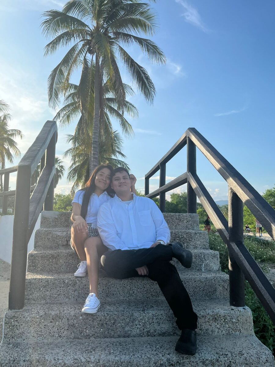 Ana Yeli y Jordi sonriendo en las escaleras de la playa
